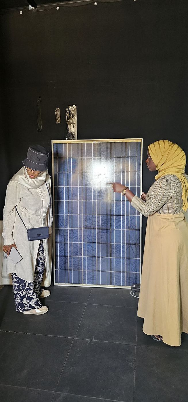 Deux femmes examinent un panneau solaire dans une salle d’essais