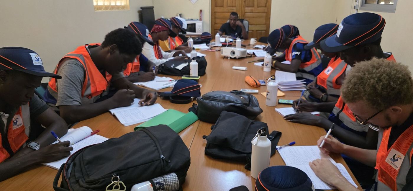 Les apprenant·e·s en gilet, autour de la table de cours