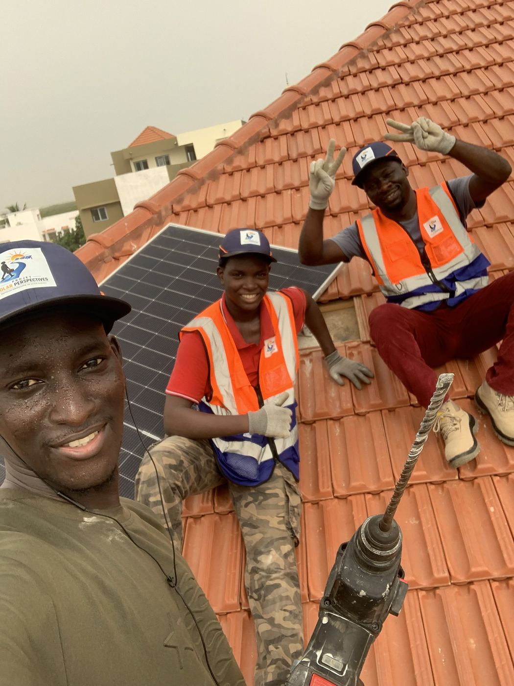 Un apprenant, souriant, sur le toit en chantier