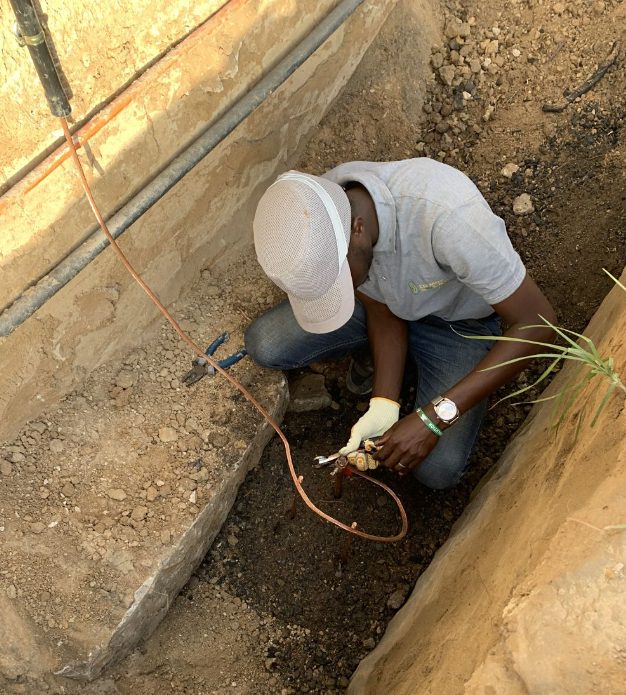 Un technicien pose les câbles dans une tranchée, le long du poste de santé
