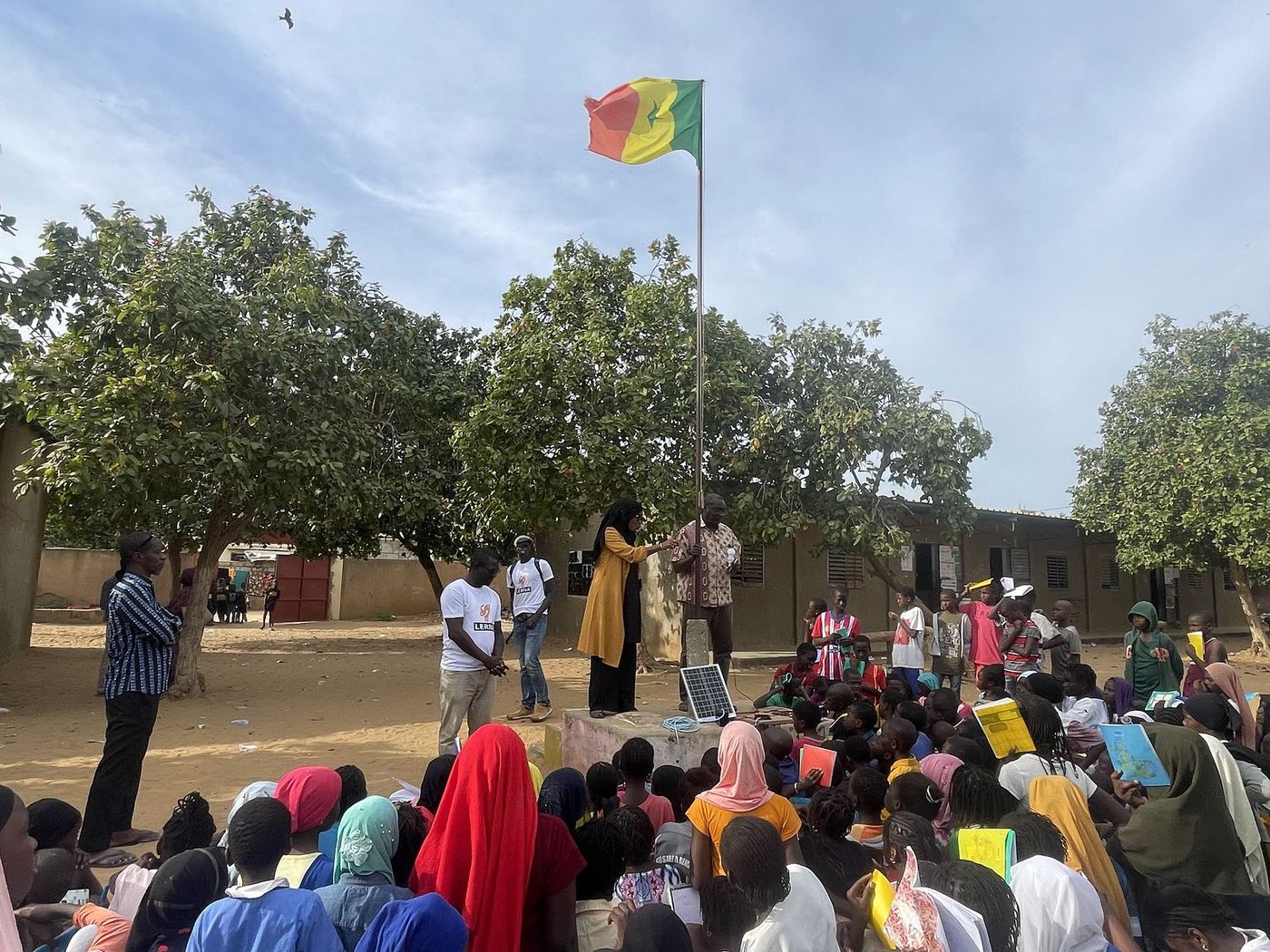 La cour de l’école sous le drapeau du Sénégal, pendant la séance