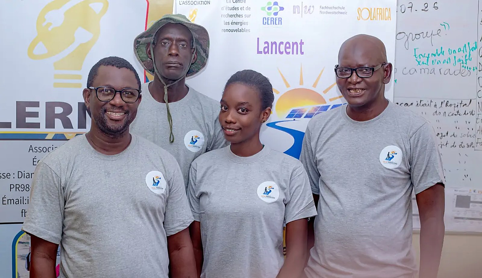 L’équipe du projet Solar Perspectives, en t-shirts gris, devant l’affiche du projet
