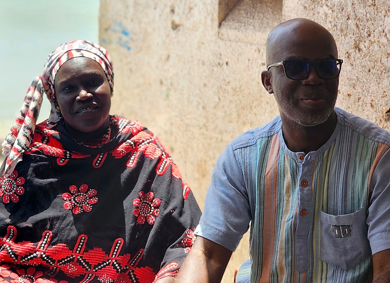Une femme et un homme souriants, assis côte à côte lors d’une rencontre
