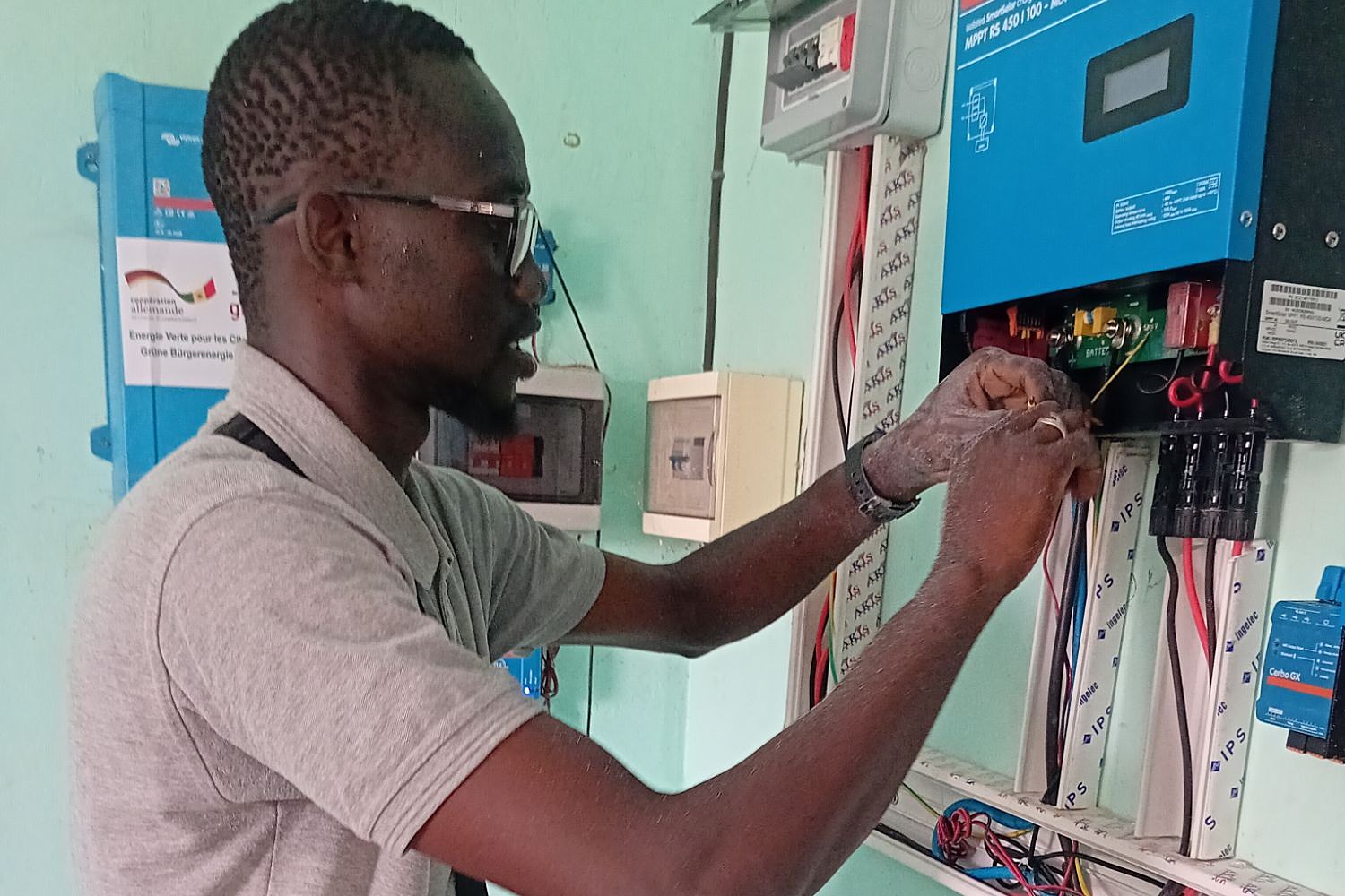 Un technicien de Lii Moy Solar raccorde le régulateur solaire d’un poste de santé