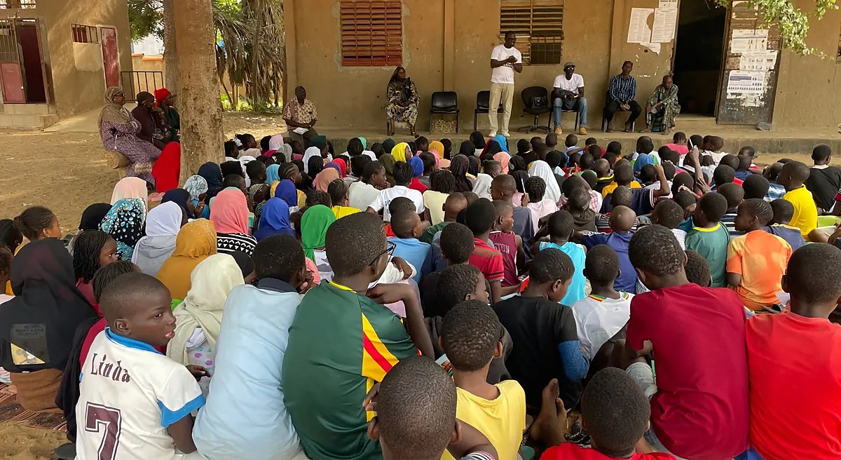 Des élèves rassemblés dans la cour d’un lycée de Jaxaay écoutent les intervenants