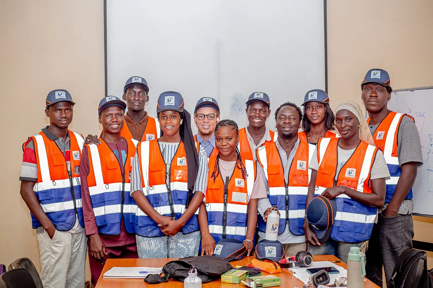 Les stagiaires de Solar Perspectives en gilet orange et casquette, réunis autour d’une table de formation