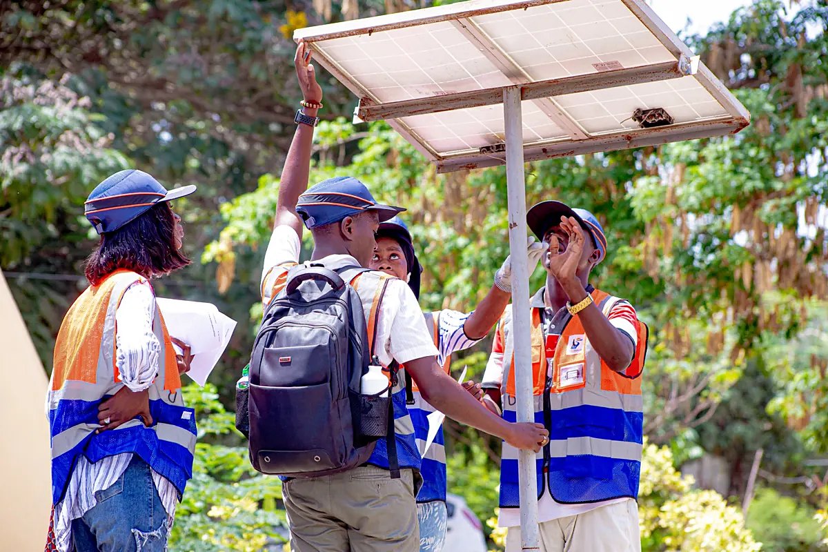Des stagiaires examinent un lampadaire solaire en plein air