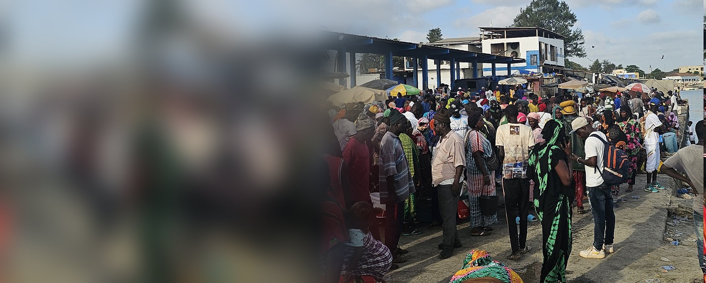 Une foule animée sur un quai de pêche au Sénégal, sous un ciel bleu